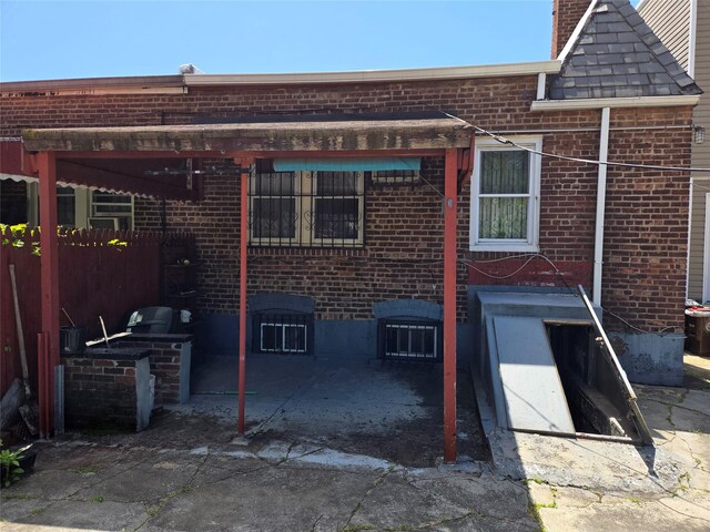 3915 Clarendon Rd, Brooklyn, NY 11203 - rear view of property featuring brick siding, exterior kitchen, fence, and a chimney