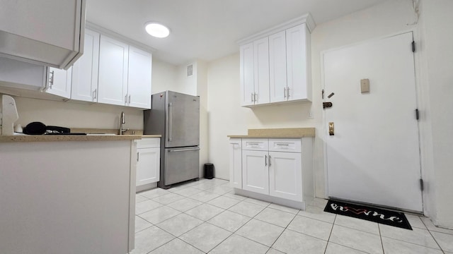 160-10 89th Ave Unit 9A, Jamaica, NY 11432 - kitchen with freestanding refrigerator, white cabinetry, light tile patterned floors, and light countertops