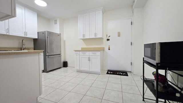 160-10 89th Ave Unit 9A, Jamaica, NY 11432 - kitchen with stainless steel appliances, light countertops, white cabinets, and light tile patterned flooring
