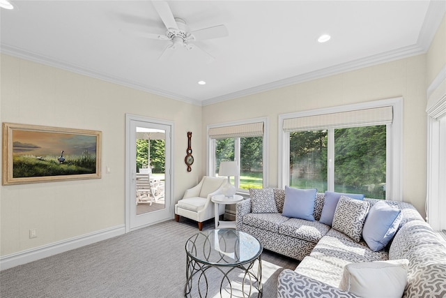 living room featuring healthy amount of natural light, ornamental molding, carpet floors, a ceiling fan, and baseboards