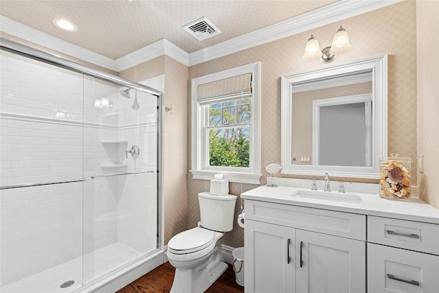 full bathroom featuring ornamental molding, a stall shower, toilet, wood finished floors, and vanity