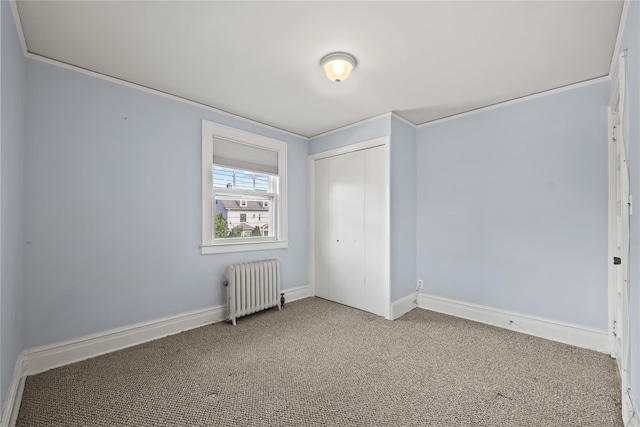 unfurnished bedroom featuring radiator heating unit, carpet flooring, a closet, and baseboards
