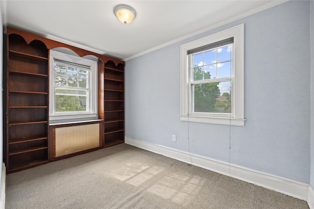 carpeted empty room featuring ornamental molding, healthy amount of natural light, and baseboards