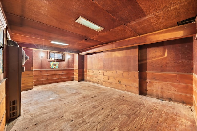 below grade area featuring wood walls, hardwood / wood-style floors, and wood ceiling