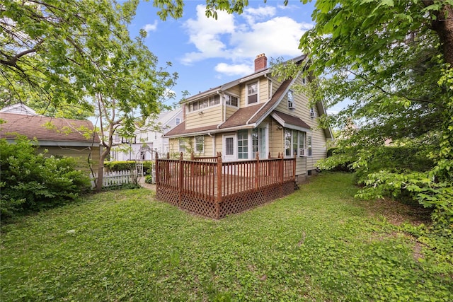 back of house featuring a chimney and a deck