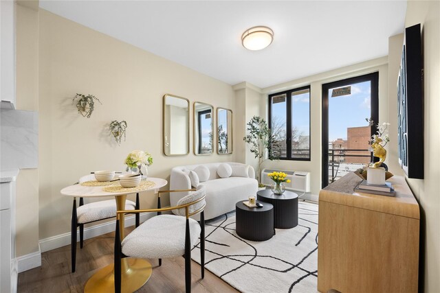 163-07 72nd Ave Unit 5C, Fresh Meadows, NY 11365 - living room featuring an AC wall unit, light wood-style flooring, and baseboards