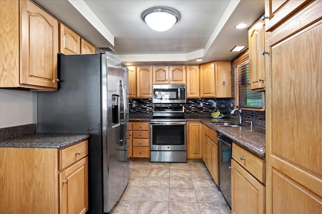 190 1st St, Buchanan, NY 10511 - kitchen featuring appliances with stainless steel finishes, a sink, decorative backsplash, dark stone countertops, and light tile patterned floors