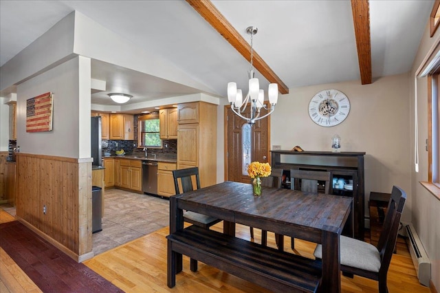 190 1st St, Buchanan, NY 10511 - dining area featuring a chandelier, light wood finished floors, a baseboard heating unit, wainscoting, and wood walls