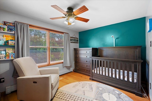 190 1st St, Buchanan, NY 10511 - bedroom with a baseboard radiator, wood finished floors, and a crib