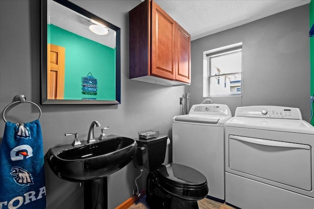190 1st St, Buchanan, NY 10511 - laundry area featuring cabinet space, washer and clothes dryer, a textured ceiling, and wood finished floors