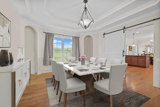 8 Tanyas Ct, Monroe, NY 10950 - dining area with a barn door, light wood-style flooring, arched walkways, ornamental molding, and a raised ceiling