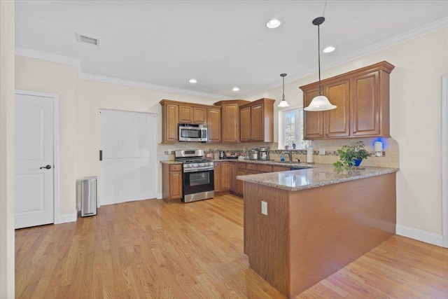 8 Tanyas Ct, Monroe, NY 10950 - kitchen with appliances with stainless steel finishes, brown cabinetry, a peninsula, light wood finished floors, and decorative backsplash