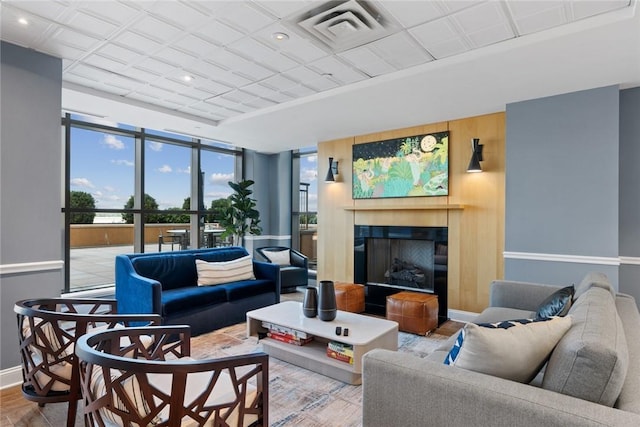 living area featuring a fireplace, baseboards, wood finished floors, and recessed lighting