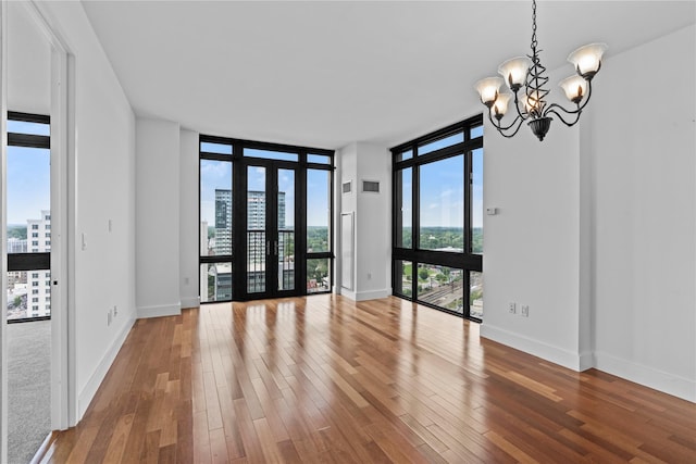 175 Huguenot St Unit 1808, New Rochelle, NY 10801 - unfurnished room with floor to ceiling windows, a chandelier, wood finished floors, and french doors
