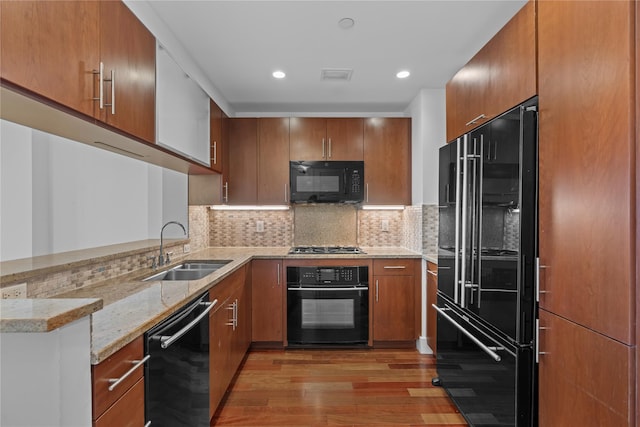 175 Huguenot St Unit 1808, New Rochelle, NY 10801 - kitchen with black appliances, light wood-type flooring, brown cabinets, light stone counters, and recessed lighting