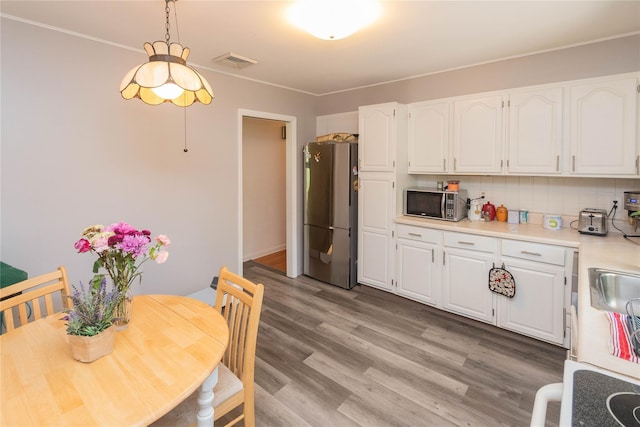 184 Cedar Valley Rd, Poughkeepsie, NY 12603 - kitchen featuring freestanding refrigerator, white cabinets, backsplash, light wood finished floors, and crown molding