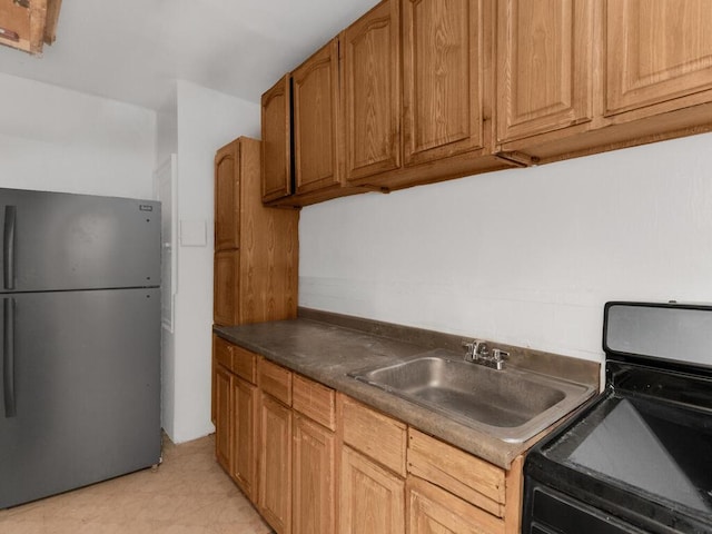1075 Grand Concourse Unit 1N, Bronx, NY 10452 - kitchen with stainless steel appliances, a sink, dark countertops, and brown cabinetry
