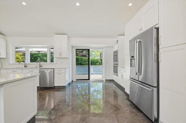 862 Fanwood Ave, North Woodmere, NY 11581 - kitchen with appliances with stainless steel finishes, dark marble finish flooring, decorative backsplash, white cabinetry, and recessed lighting
