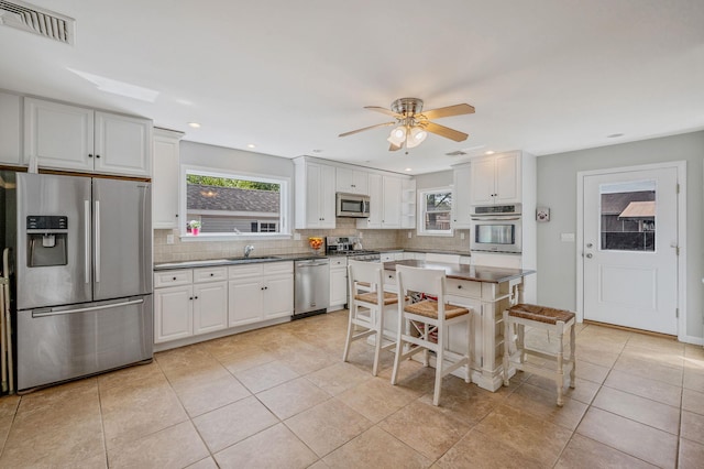 kitchen featuring stainless steel appliances, a sink, tasteful backsplash, healthy amount of natural light, and recessed lighting