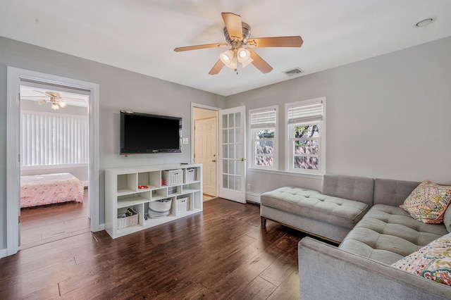 living room featuring a ceiling fan and dark wood-type flooring