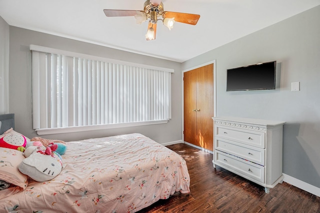 bedroom featuring baseboards, dark wood finished floors, a closet, and ceiling fan