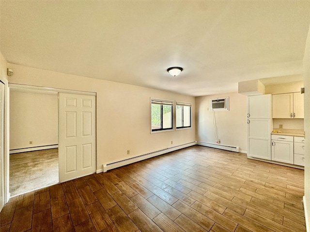 8 Ebury, Middletown, NY 10940 - unfurnished living room with a baseboard heating unit, wood finished floors, a wall unit AC, and a baseboard radiator
