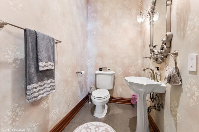 bathroom with toilet and baseboards