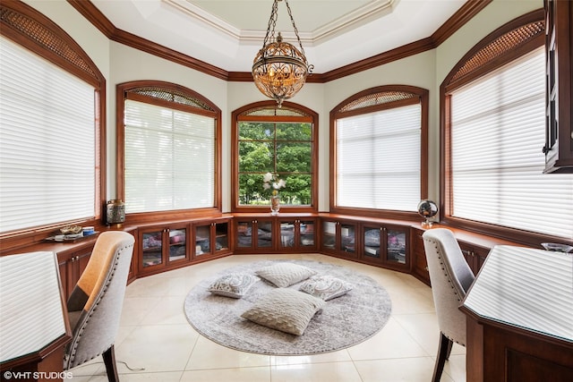 dining space with a tray ceiling, ornamental molding, light tile patterned flooring, and a chandelier