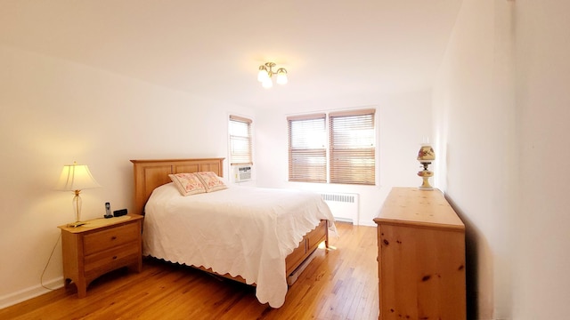 109 N Broadway Unit M12, White Plains, NY 10603 - bedroom with radiator heating unit, light wood-type flooring, and baseboards