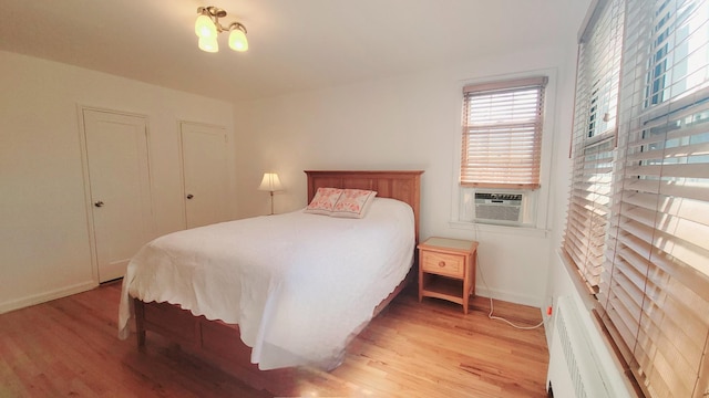 109 N Broadway Unit M12, White Plains, NY 10603 - bedroom with light wood-style floors, cooling unit, and baseboards