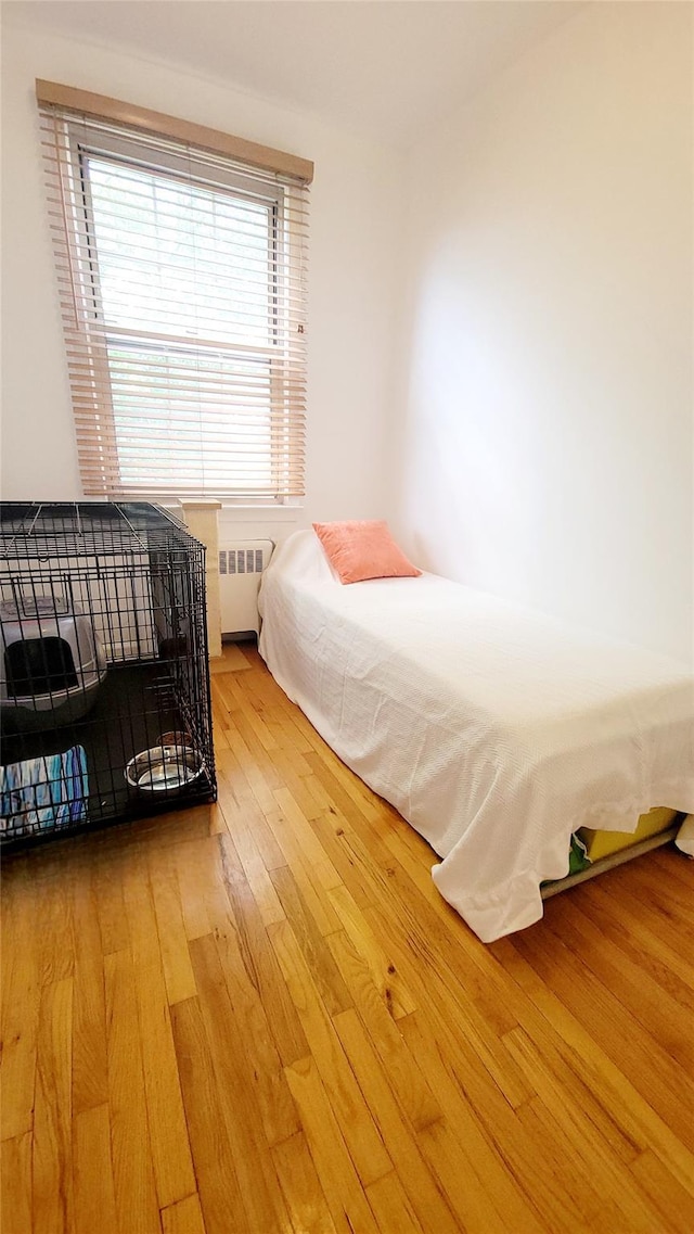 109 N Broadway Unit M12, White Plains, NY 10603 - bedroom with radiator heating unit and hardwood / wood-style flooring