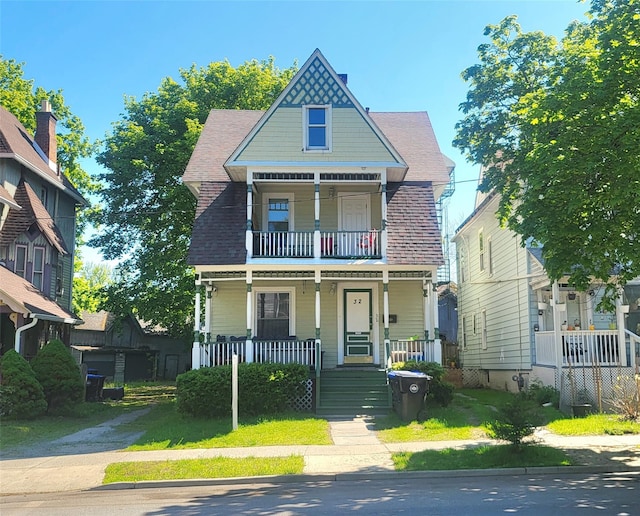 32 Hooker Ave, Poughkeepsie, NY 12601 - victorian house with covered porch, a balcony, and roof with shingles