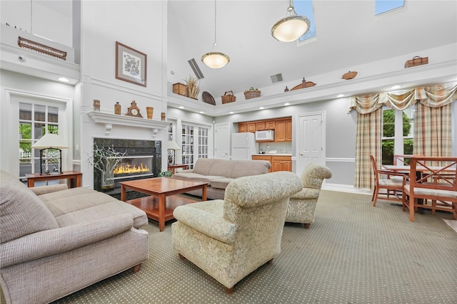 701 Pheasant Woods Rd, Briarcliff Manor, NY 10510 - living area with high vaulted ceiling, light colored carpet, a fireplace, baseboards, and healthy amount of natural light