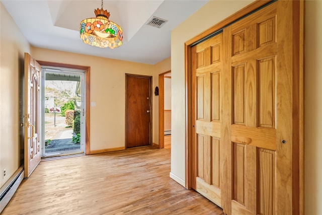 359 Old Bridge Rd, East Northport, NY 11731 - entrance foyer with baseboard heating, light wood finished floors, baseboards, and a baseboard heating unit
