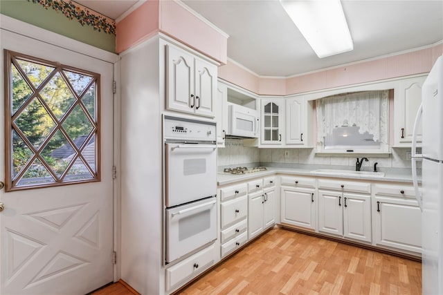 359 Old Bridge Rd, East Northport, NY 11731 - kitchen featuring white appliances, a sink, light countertops, light wood-style flooring, and white cabinets