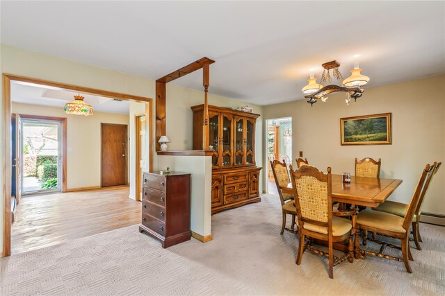 359 Old Bridge Rd, East Northport, NY 11731 - dining area with a chandelier, light colored carpet, and baseboards