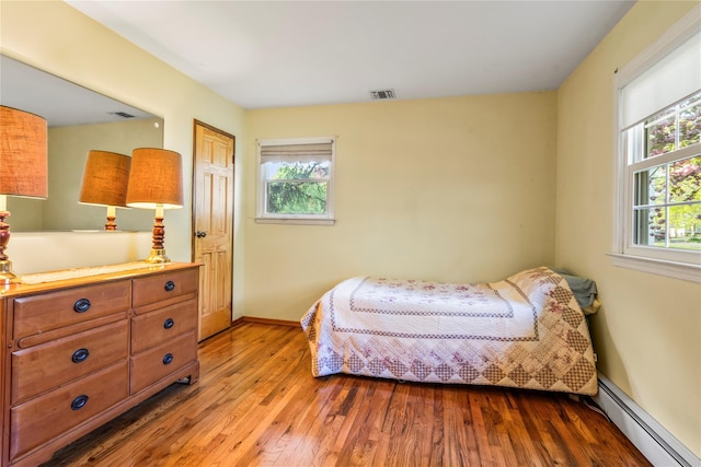 359 Old Bridge Rd, East Northport, NY 11731 - bedroom with a baseboard heating unit, hardwood / wood-style flooring, and baseboards