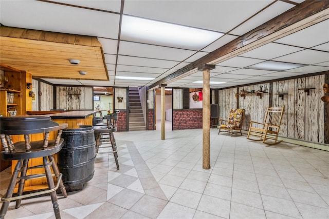 359 Old Bridge Rd, East Northport, NY 11731 - finished basement with a paneled ceiling, a dry bar, wooden walls, stairway, and tile patterned flooring