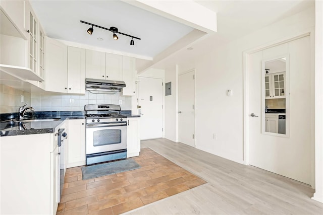 9305 37th Ave Unit 3D, Jackson Heights, NY 11372 - kitchen featuring gas range, under cabinet range hood, dark countertops, tasteful backsplash, and white cabinets