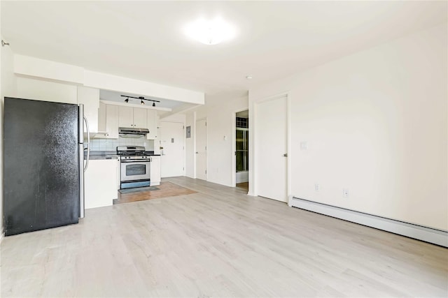 9305 37th Ave Unit 3D, Jackson Heights, NY 11372 - kitchen with appliances with stainless steel finishes, under cabinet range hood, a baseboard radiator, white cabinets, and light wood finished floors