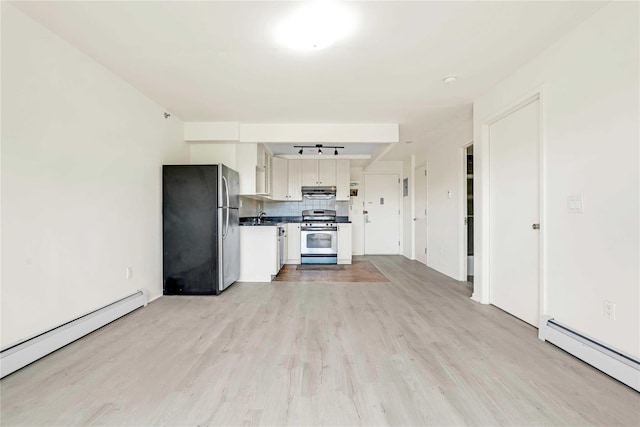 9305 37th Ave Unit 3D, Jackson Heights, NY 11372 - kitchen with appliances with stainless steel finishes, baseboard heating, dark countertops, and light wood finished floors