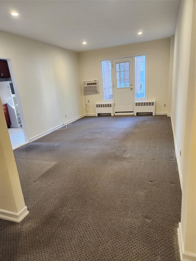 285 Central Ave Unit B4, Lawrence, NY 11559 - empty room featuring dark carpet, radiator, a wall unit AC, recessed lighting, and baseboards