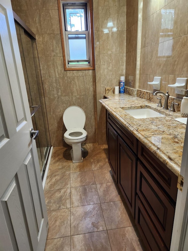 285 Central Ave Unit B4, Lawrence, NY 11559 - bathroom featuring tile walls, vanity, a stall shower, and toilet