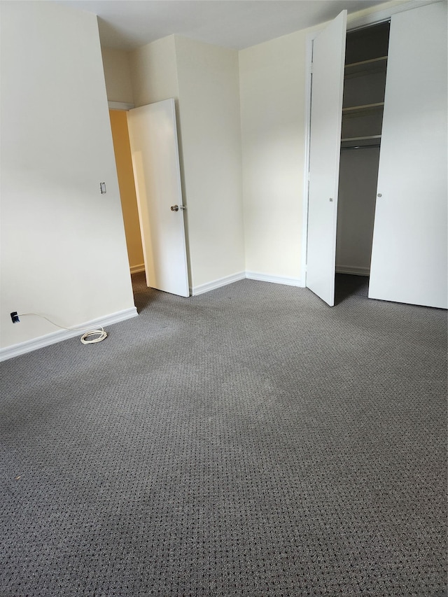 285 Central Ave Unit B4, Lawrence, NY 11559 - unfurnished bedroom with dark carpet, baseboards, and a closet