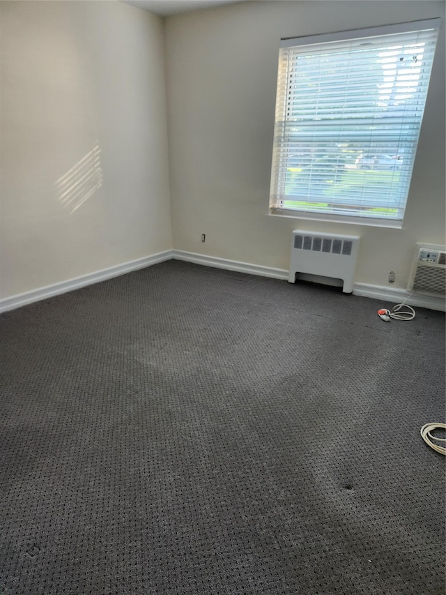 285 Central Ave Unit B4, Lawrence, NY 11559 - empty room featuring radiator, baseboards, dark carpet, and a wall mounted AC
