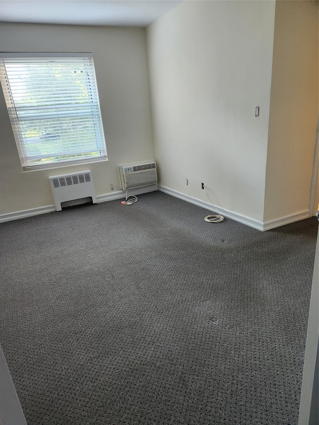 285 Central Ave Unit B4, Lawrence, NY 11559 - empty room featuring radiator heating unit, dark carpet, a wall mounted AC, and baseboards
