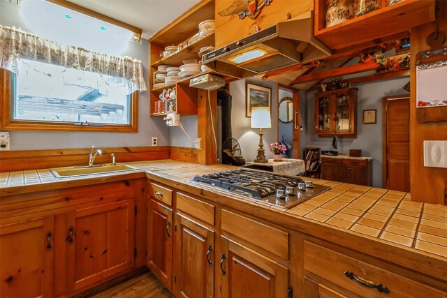 57 Empire Dr, Patterson, NY 12563 - kitchen featuring tile counters, a sink, brown cabinets, stainless steel gas stovetop, and wood finished floors