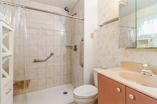 57 Empire Dr, Patterson, NY 12563 - full bath featuring wallpapered walls, vanity, tiled shower, and toilet