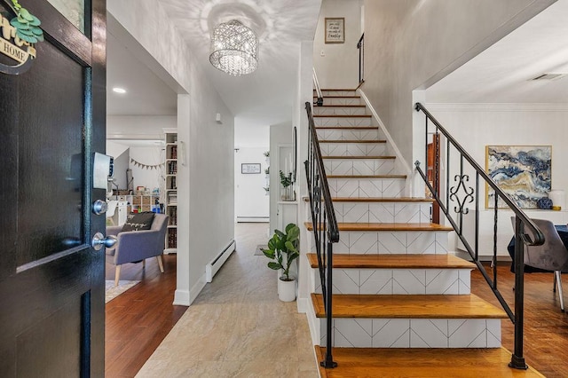 entrance foyer with a baseboard heating unit, stairway, wood finished floors, and a chandelier