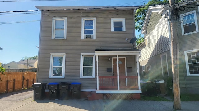 back of house with fence and covered porch